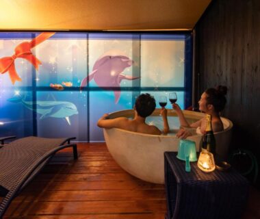 Two guests relaxing in round soaking tub with painted screen at XYZ Private Spa and Seaside Resort, Wakayama