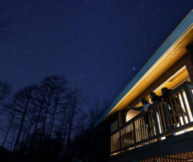 Guests on wooden balcony under starry sky at Yatsugatake Kogen Resort in Yamanashi