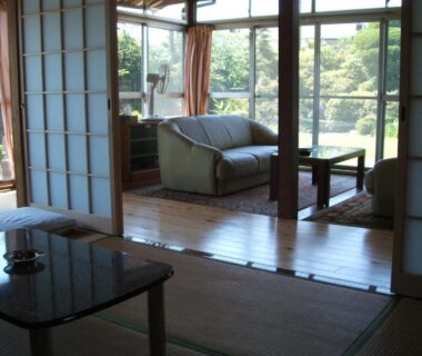 Traditional tatami room with shoji screens and seating overlooking garden at YOKOSO Ryokan Oita