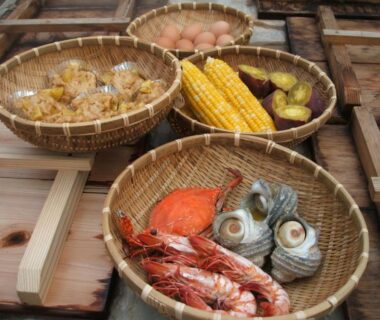 Woven baskets holding shrimp, crab, shellfish, corn and eggs at YOKOSO Ryokan in Ōita, Kyūshū