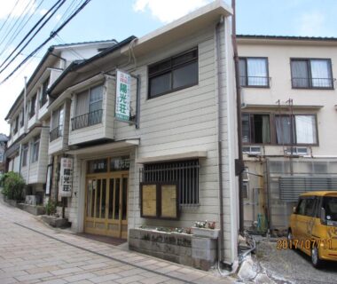 Entrance of YOKOSO Ryokan on a narrow street in Ōita, Kyūshū