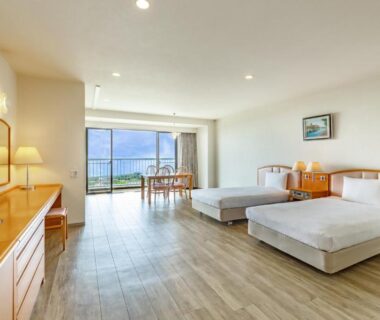 Bright twin western-style room with wooden floor, TV and balcony doors at YU-FURI Izukogen in Shizuoka