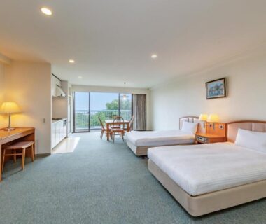 Twin beds and balcony overlooking green hills at YU-FURI Izukogen in Shizuoka, Chūbu Japan