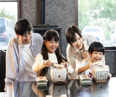 Family of four pouring tea from ceramic pots on a polished counter at YU-FURI Nasu-Takao Onsen Lodge Tochigi