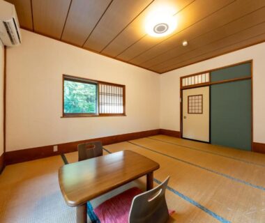Traditional tatami room with low table, zaisu chairs and shoji windows at YUPOPPO Hakone in Kanagawa
