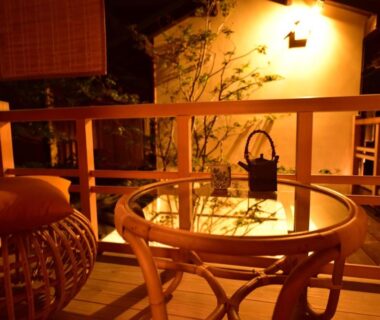 Warm lit wooden veranda with rattan chairs and iron kettle at Yado Kiramachi in Kyoto