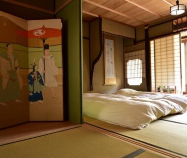 Traditional tatami room with futon bedding, shoji screens and decorative painted folding screen at Yado Kiramachi Kyoto