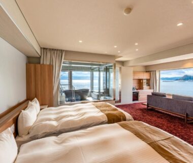Two beds, sofa and balcony with sea view at Yado Nakaya, Chiba, Kantō