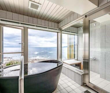Black soaking tub by window overlooking sea at Yado Nakaya in Chiba, Kanto