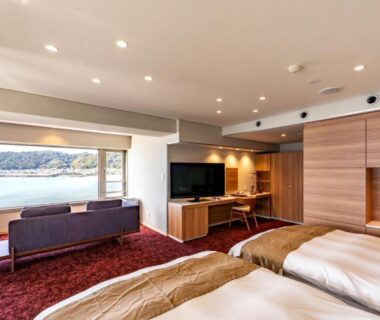 Twin beds, lounge seating and coastal view at Yado Nakaya in Chiba, Kantō, Japan