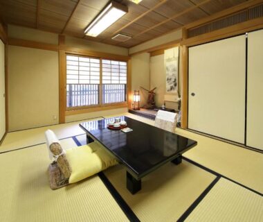 Traditional tatami room with low table, cushions, shoji screens and sliding doors at Yadoya Kikokuso, Kyoto