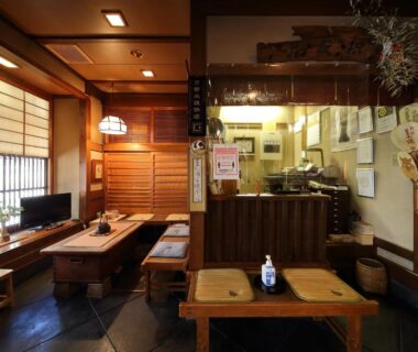 Low wooden tables, shoji screens, and reception counter at Yadoya Kikokuso in Kyoto