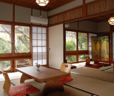 Traditional tatami room with low table, floor chairs, shoji screens and garden view at Yadoya Manjiro Kyoto