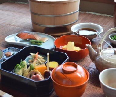 Assorted Japanese breakfast dishes on low table with teapot and rice at Yadoya Manjiro Kyoto