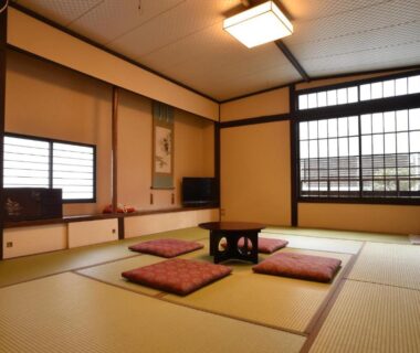 Traditional tatami room with low table, zabuton cushions and shoji window at Yadoya Nishijinso, Kyoto