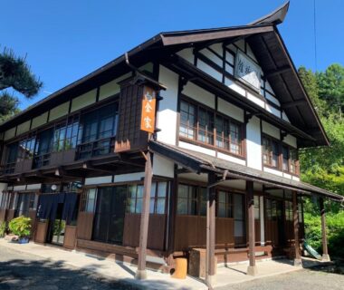 Two-story wooden ryokan exterior with latticed windows at Yadoya Shiroganeya in Nagano