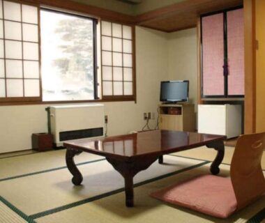 Traditional tatami room with low wooden table, floor cushion and shoji windows at Yakushi no Yu Yumotokan, Gunma