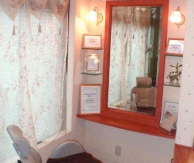 Vanity with mirror, cushioned chair and floral curtains at Yakushi no Yu Yumotokan Kanto