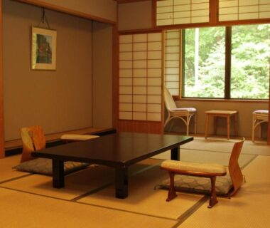 Tatami room with low table, shoji screens, and greenery view at Yamabiko in Nagano, Chūbu