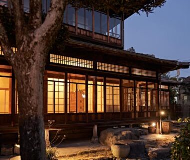 Illuminated wooden facade with shoji windows and stone garden at dusk at Yamada Bessou Oita