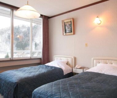 Two single beds with blue bedcovers and window showing snowy mountain, Yamadaya Hotel Yamanashi
