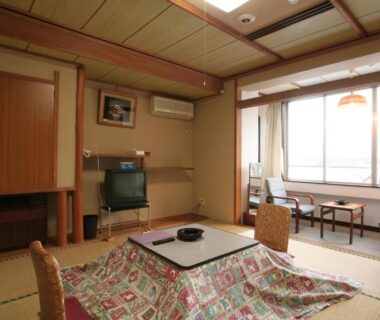 Traditional tatami room with low table and kotatsu, floor chairs, shoji screens and window seating at Yamadaya Hotel Yamanashi