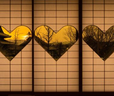 Three heart-shaped cutouts in shoji screens backlit with silhouetted trees at Yamadaya Ryokan Kyoto