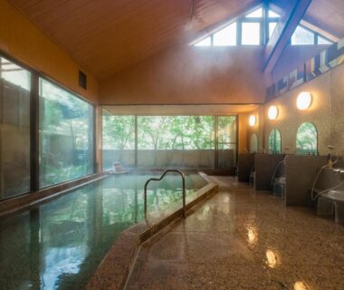 Indoor onsen with wooden vaulted ceiling and large windows at Yamagaso, Kanagawa, Kantō