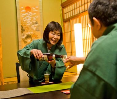 Two guests in yukata sharing a drink at a low table in Yamagaso tatami room, Kanagawa, Kantō, Japan