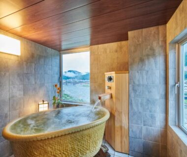 Indoor onsen tub by window overlooking mountains and town at Yamagataya, Gifu, Chūbu