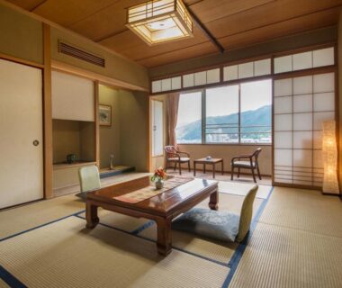 Traditional tatami room with low table, shoji screens and mountain view at Yamagataya in Gifu, Chūbu