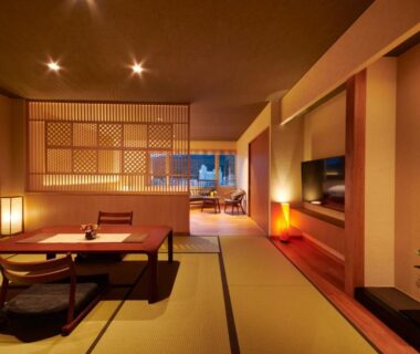 Spacious tatami room with low table, floor cushions, shoji screens and warm ambient lighting at Yamagataya in Gifu