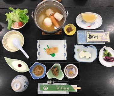 Assorted small dishes with tabletop hot pot on lacquer tray at Yamagisi Ryokan, Yamanashi, Chūbu