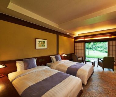 Twin beds with shoji screens and seating area overlooking garden at Yamaha Resort Katsuragi Kitanomaru Shizuoka