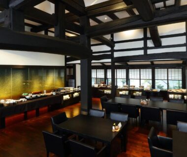Spacious dining room with exposed timber beams, tables and chairs, garden-facing windows at Yamaha Resort Katsuragi Kitanomaru Shizuoka