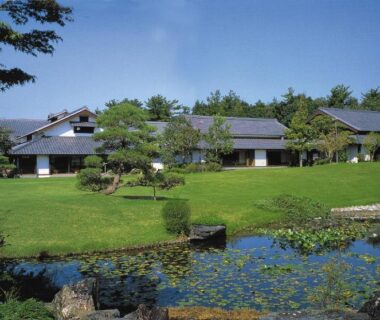 Pond and manicured lawn with Yamaha Resort Katsuragi Kitanomaru buildings in Chūbu, Shizuoka