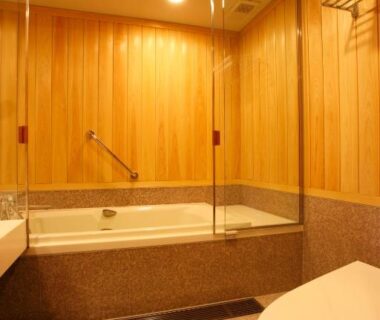 Interior wood-paneled bathing area with tub and toilet at Yamaha Resort Katsuragi Kitanomaru in Shizuoka