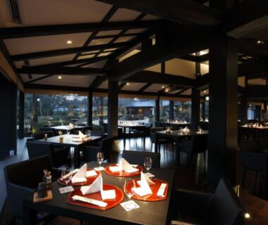 Low-lit dining room with set tables at Yamaha Resort Katsuragi Kitanomaru in Shizuoka, Chūbu, Japan