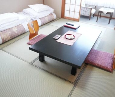 Traditional tatami room with low table, zabuton cushions and folded futons at Yamaichi, Iwate, Tōhoku