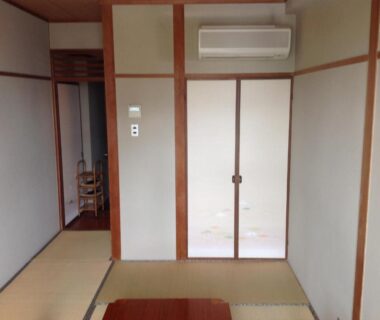 Traditional tatami room with fusuma sliding doors and wall-mounted air conditioner at Yamaichi Bekkan, Hiroshima