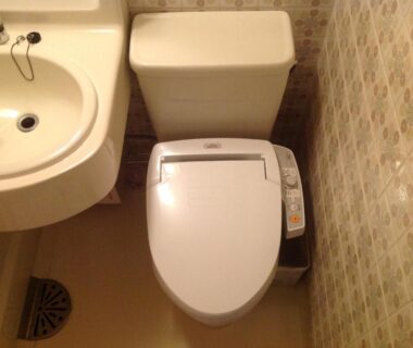 Compact bathroom with electronic bidet toilet and sink at Yamaichi Bekkan, Hiroshima