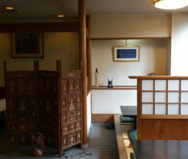 Interior dining area with shoji screens, wooden partition and table seating at Yamaichi Bekkan in Hiroshima