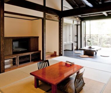 Traditional tatami room with low table, zaisu chairs and sliding doors to a garden-facing veranda at Yamakikan in Gunma