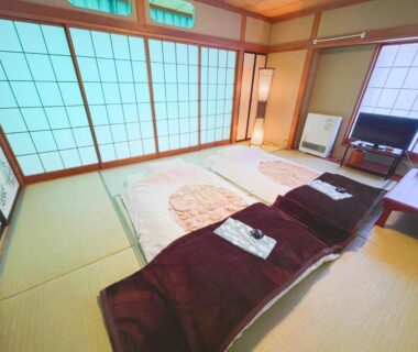 Tatami room with futons and shoji screens at Yamanaka Lake Ryozan in Yamanashi Chūbu