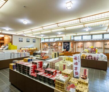 Interior view of ryokan gift shop with boxed local souvenirs and display tables at Yamanaka Onsen Hanatsubaki, Ishikawa