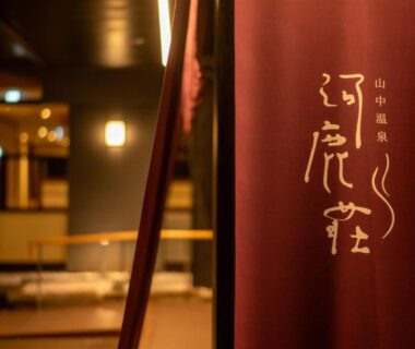 Noren curtain at entrance of Yamanaka Onsen Kajikaso showing warm-lit interior Ishikawa Chūbu Japan
