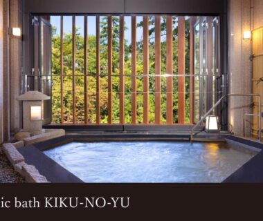Public indoor onsen bath with wooden slatted window and garden view at Yamanaka Onsen Kissho Yamanaka