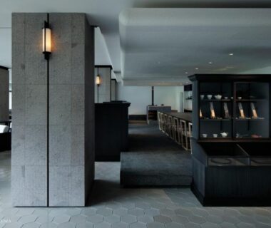 Lobby with stone columns, lantern lighting, seating and wooden shoe shelving at Yamanakaonsen Hanamurasaki, Ishikawa