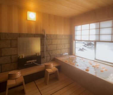 Indoor wooden soaking tub with stools and shoji window at Yamanoo, Ishikawa, Chūbu