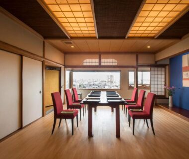 Tatami dining room with long table, red chairs and shoji screens at Yamanoo, Ishikawa, Chūbu